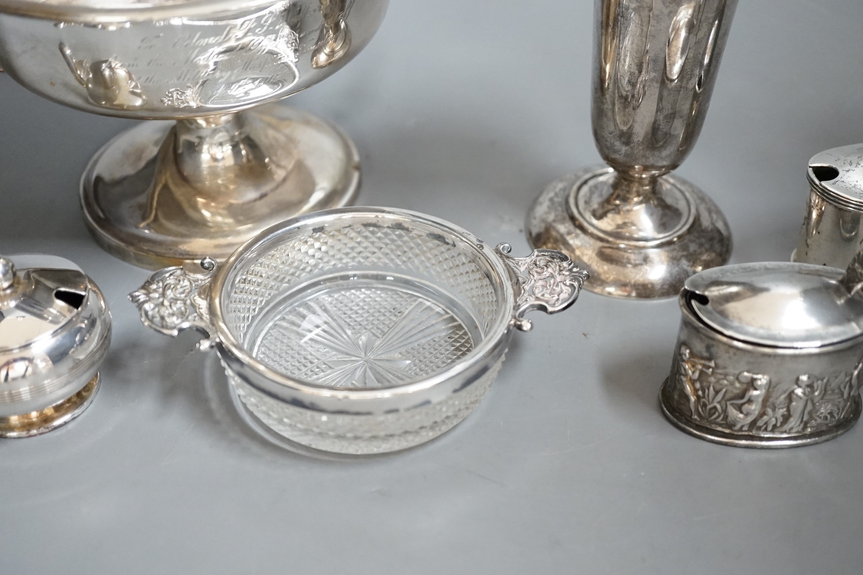 A group of assorted small silver items to include a posy vase, silver-mounted cut glass quaich, a twin-handled silver cup and three condiments.